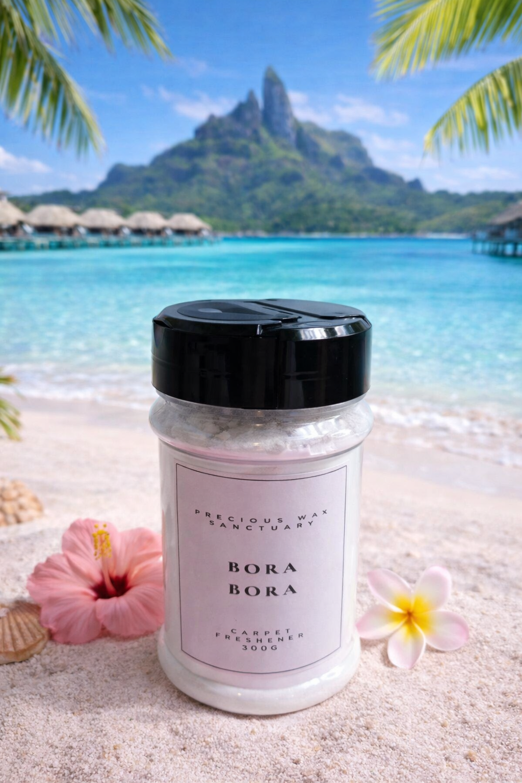 Jar labeled 'Bora Bora' carpet freshener on a sandy beach with tropical flowers and mountains in the background