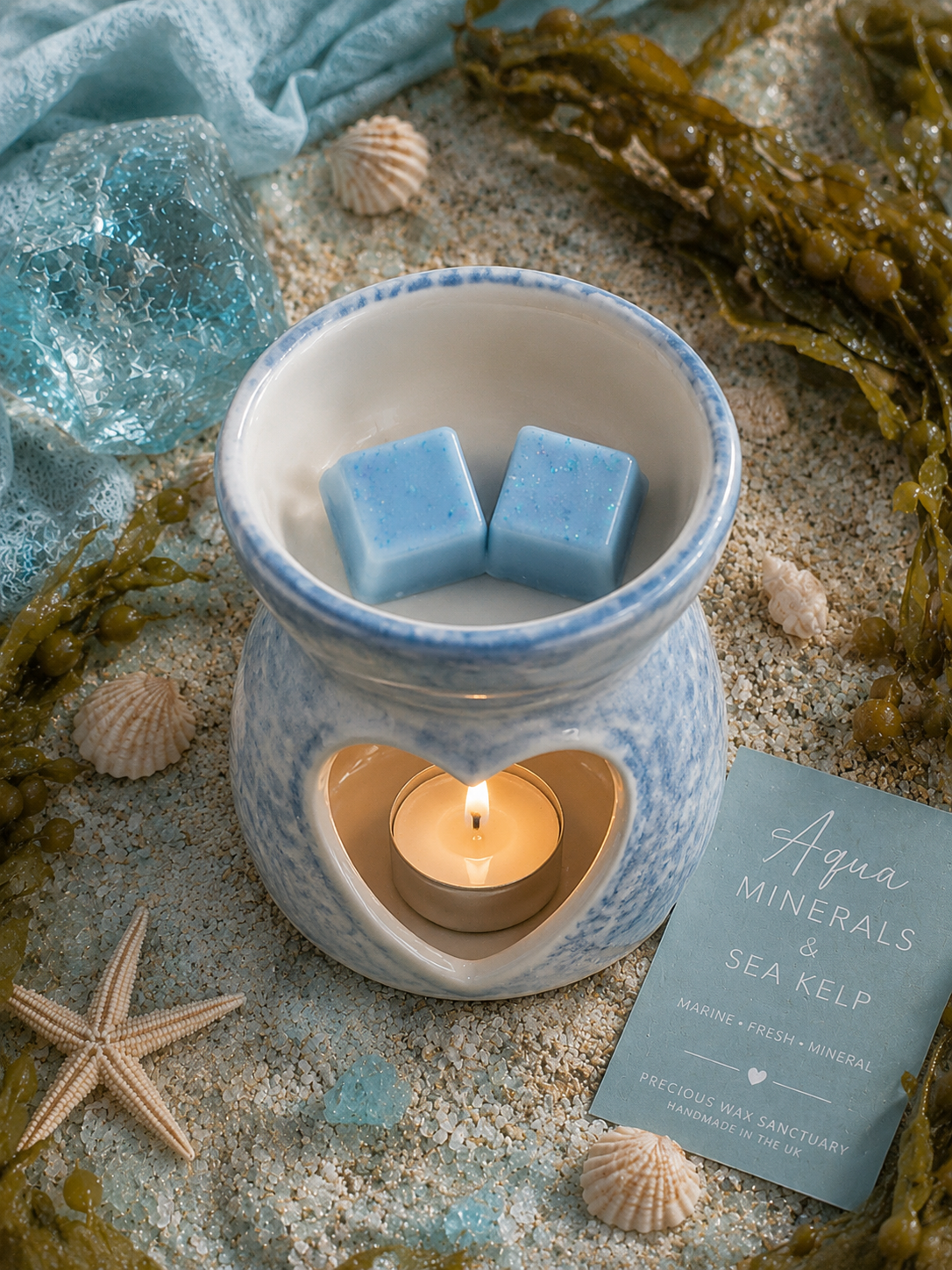 Blue wax melts in burner surrounded by sea and shells.