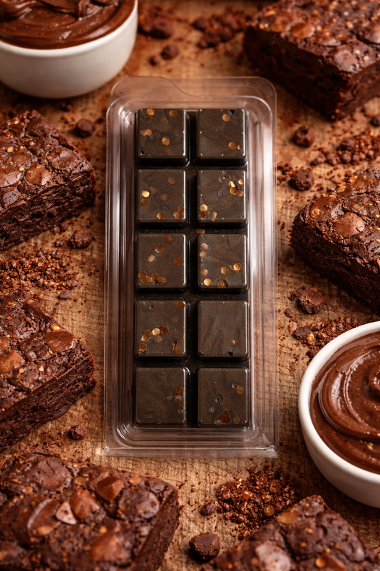 brownie batter wax melts on a wooden surface with brownies and chocolate spread.