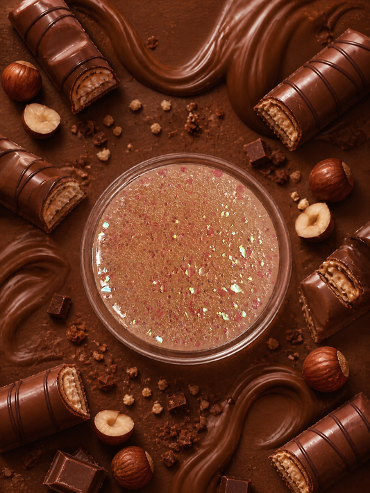 Bueno bliss wax melt pot surrounded by chocolate and hazelnuts.