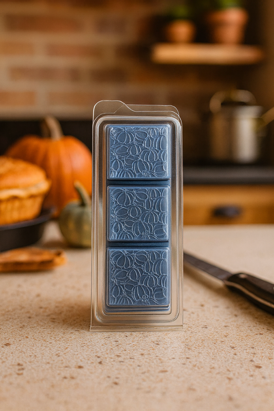 A vibrant wax melt in warm orange and purple tones, releasing a fruity and spicy aroma of pumpkin, blueberries, orange, cinnamon, vanilla, and dried fruits.