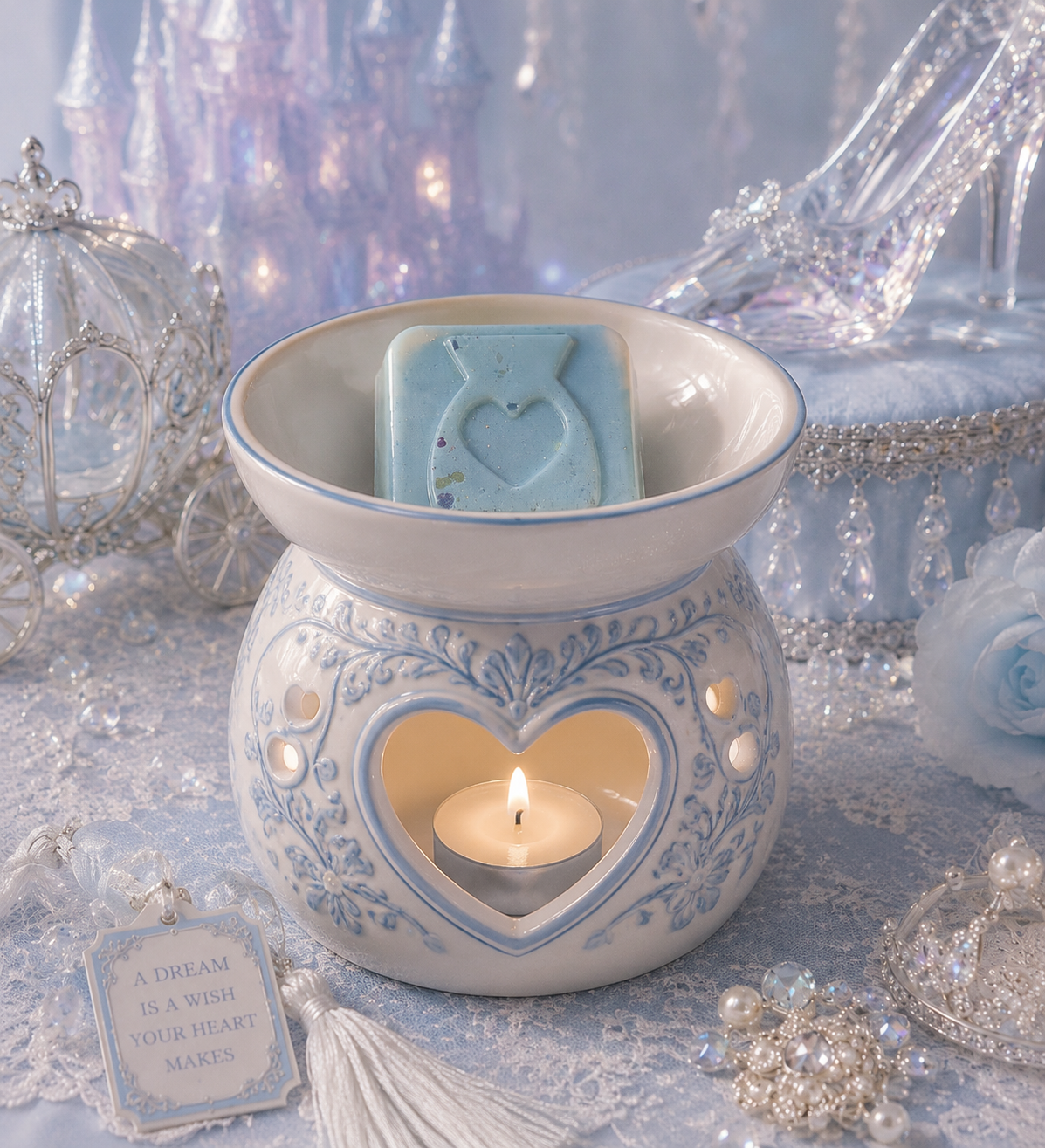 A ceramic wax warmer with a blue floral pattern and a heart-shaped wax melt, holding a lit tealight candle. A light blue soap bar with a heart design sits in the bowl above.