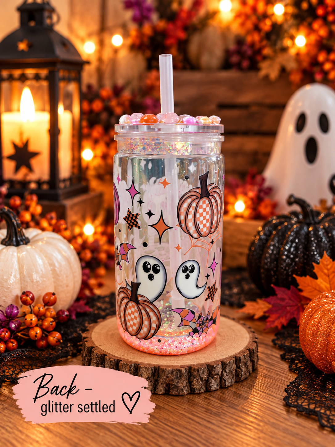 16oz halloween theme snowglobe tumbler from the back glitter settled with halloween decor.