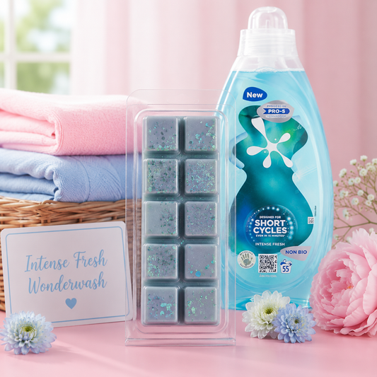 Bottle of laundry detergent with dryer sheets and flowers with wax melt on a pink background