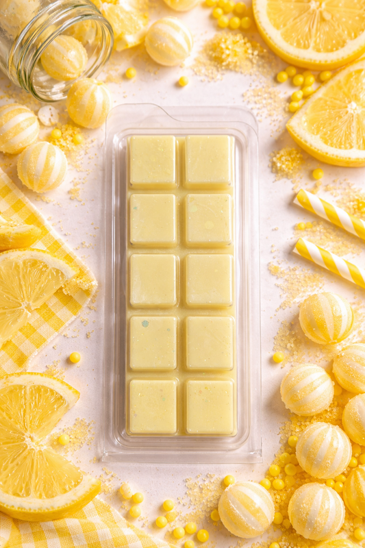 Packaged yellow wax melts with lemon slices and candies on a light background