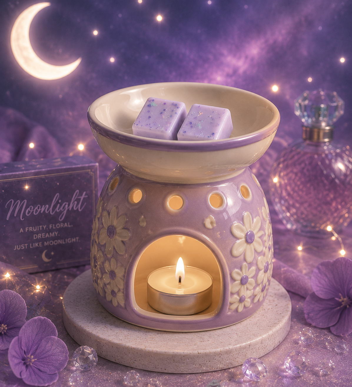 A lavender and cream ceramic wax warmer with a floral pattern, featuring a bowl with two wax melts and a lit tealight candle inside. The warmer sits on a stone base, surrounded by purple flowers, glitter, and a decorative box labeled 'Moonlight' against a purple galaxy night sky backdrop.