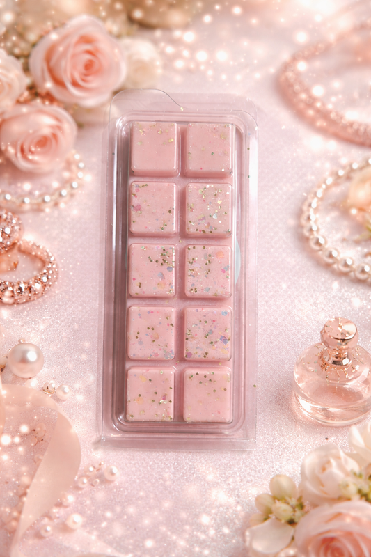 Pink fizz wax melt bar surrounded by perfume and roses.