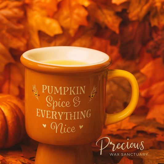 Orange mug with 'Pumpkin Spice & Everything Nice' text in a fall setting with leaves and pumpkin.