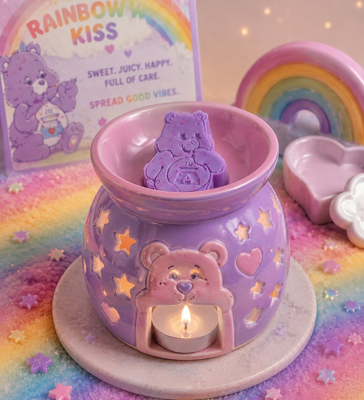 A pastel purple ceramic candle warmer shaped like a bear, with star and heart cutouts, a small tea light candle lit inside, and a purple bear-shaped wax melt placed in the saucer. Rainbow-themed props and packaging are visible around it on a soft pastel background.