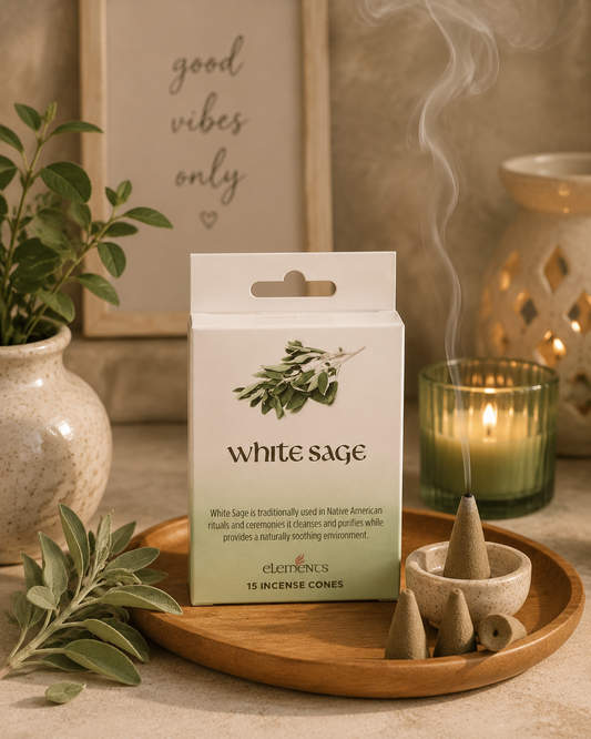 A box of ELEKTRENS White Sage incense cones stands on a wooden tray beside a lit candle, a small bowl with incense cones, and sage leaves in a softly styled indoor setting.