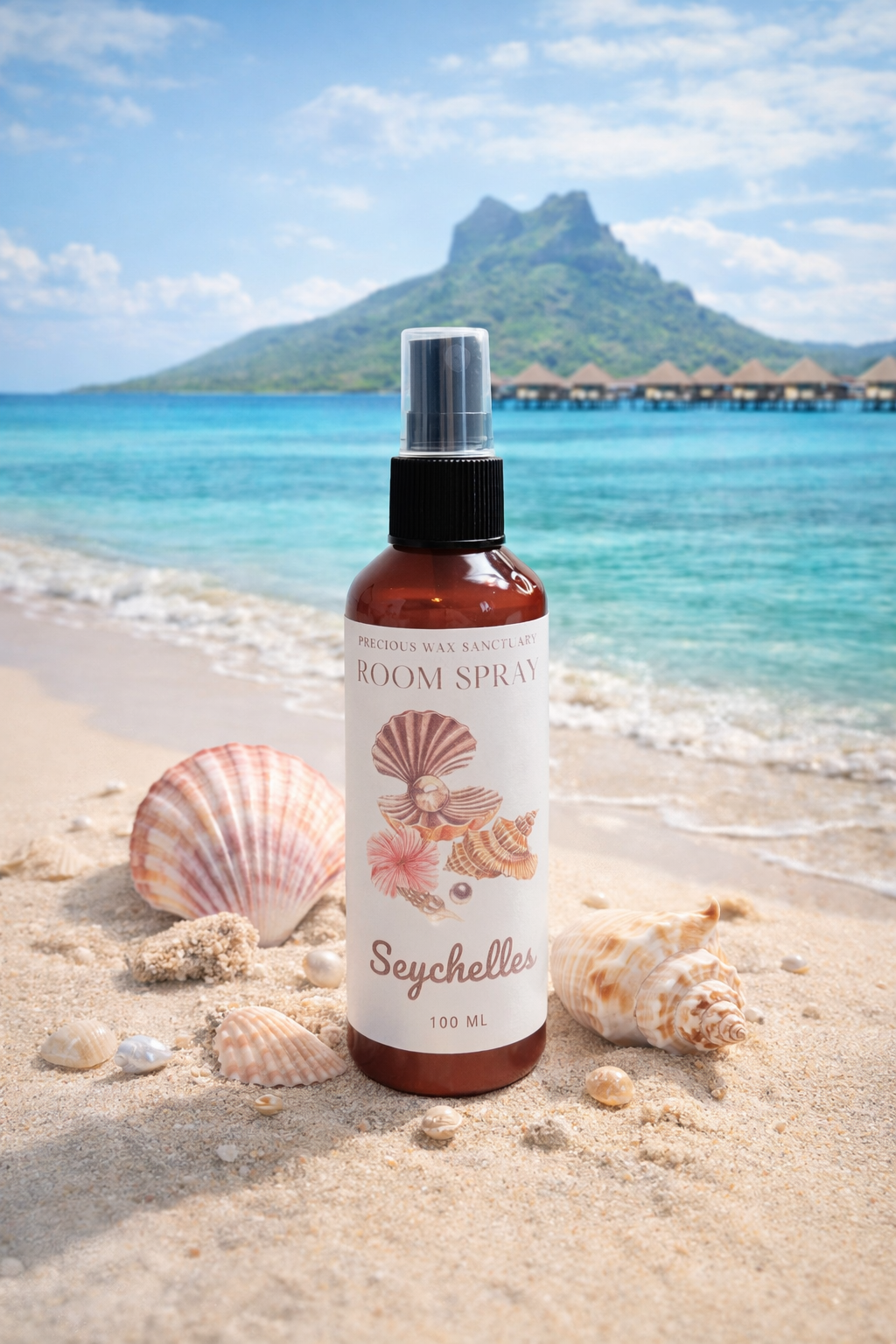 Bottle of room spray with seashell design on a beach with ocean and mountain in the background