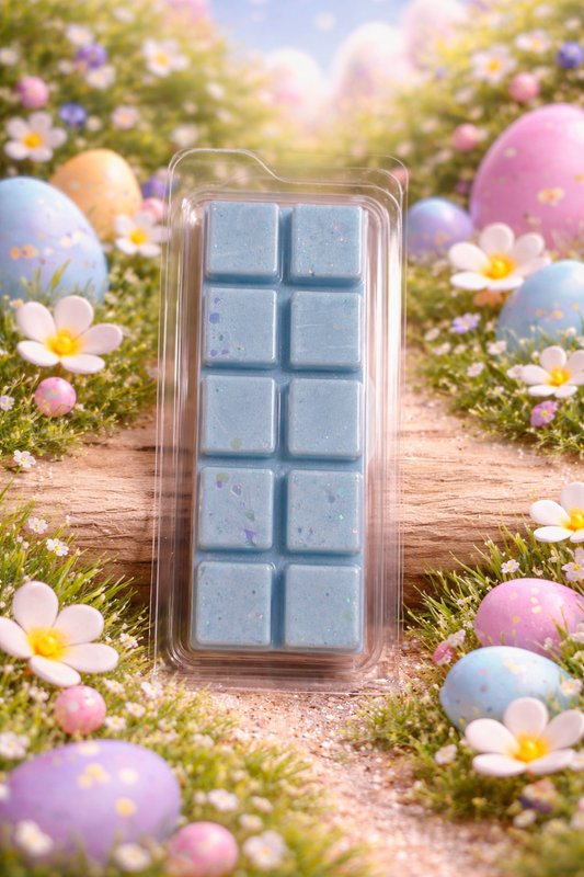 Pack of blue wax melts in a clear plastic case with Easter eggs and flowers in the background