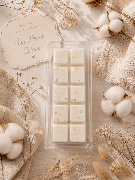 A wax melt set in a clear plastic clamshell package, labeled 'Sun Dried Cotton' by Precious Wax Sanctuary. The wax melts are off-white with tiny multicolored speckles.