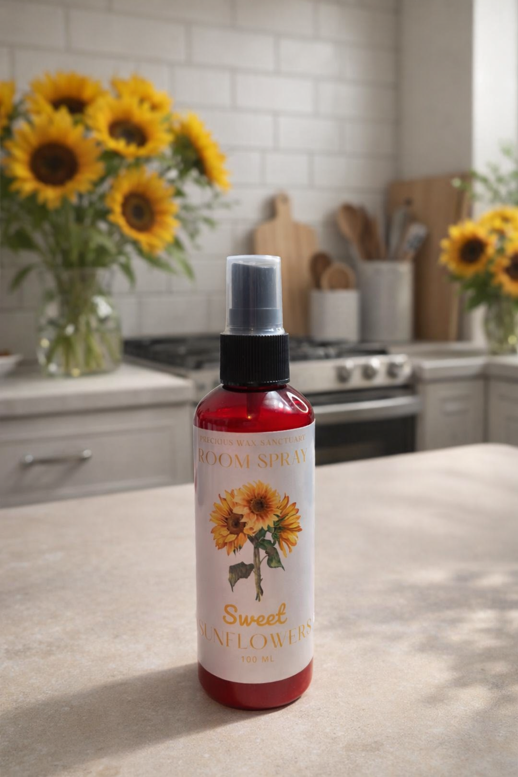 Bottle of 'Sweet Sunflowers' room spray on a kitchen counter with sunflower decorations.