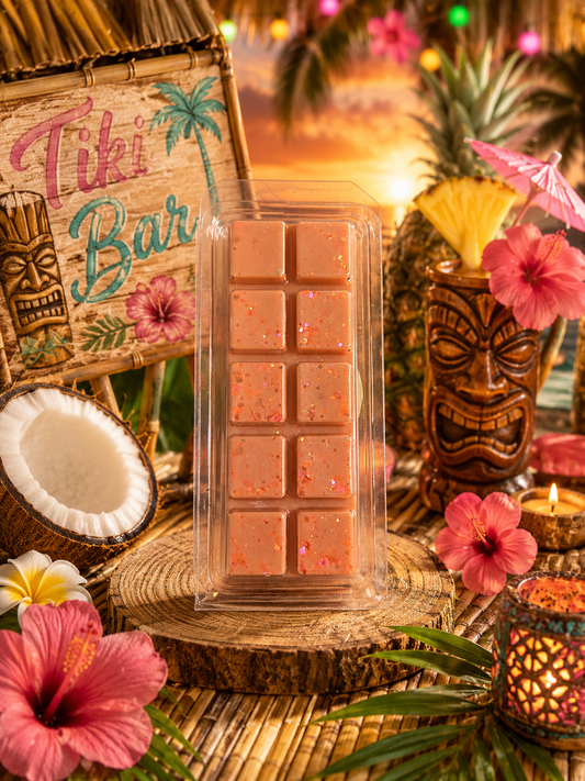 Tropical-themed setting with a tiki bar wax melt with sign, pineapple, and floral decorations.
