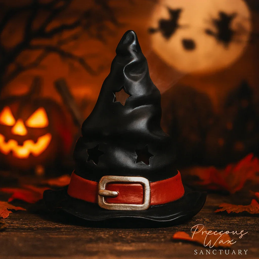 Black witch hat incense burner with a red belt on a wooden surface with Halloween-themed background